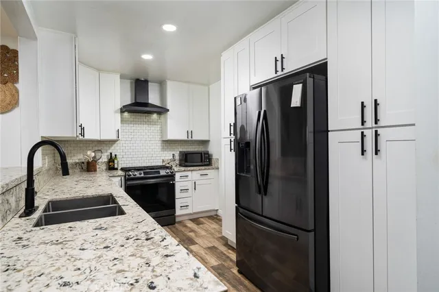 a kitchen with stainless steel appliances granite countertop a refrigerator a stove a sink and a refrigerator