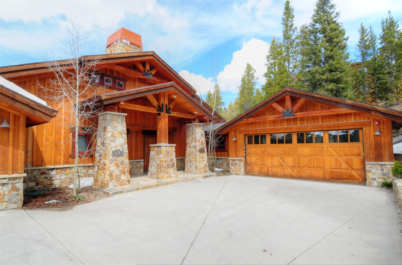 59 Club House Road, Unit C Breckenridge, CO 80424 - Photo 45 of 50 View of front facade featuring stone siding, a garage, an outdoor structure, a patio area, and ceiling fan