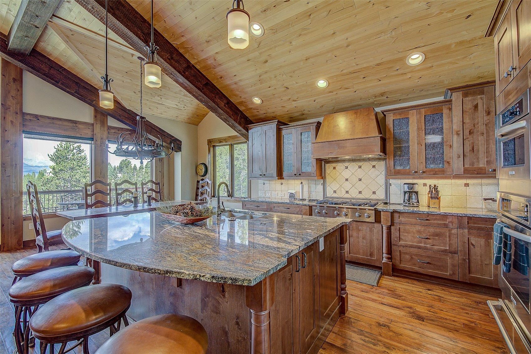 59 Club House Road, Unit C Breckenridge, CO 80424 - Photo 6 of 50 Kitchen with a kitchen breakfast bar, tasteful backsplash, glass insert cabinets, hanging light fixtures, and dark stone counters