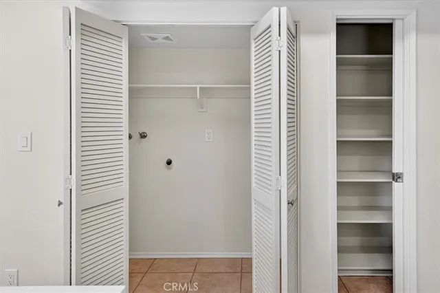 a view of walk in closet with empty racks