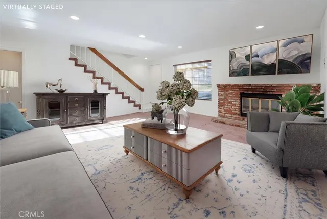 a living room with furniture a fireplace and a potted plant