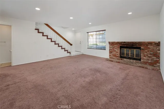 an empty room with fireplace and windows