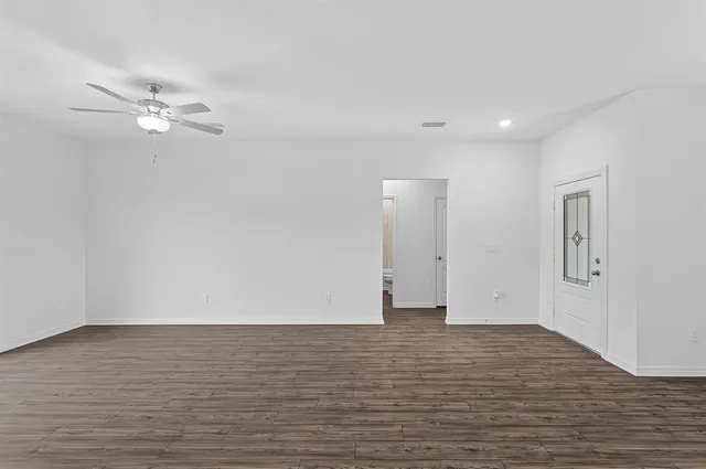 a view of a room with wooden floor and fan