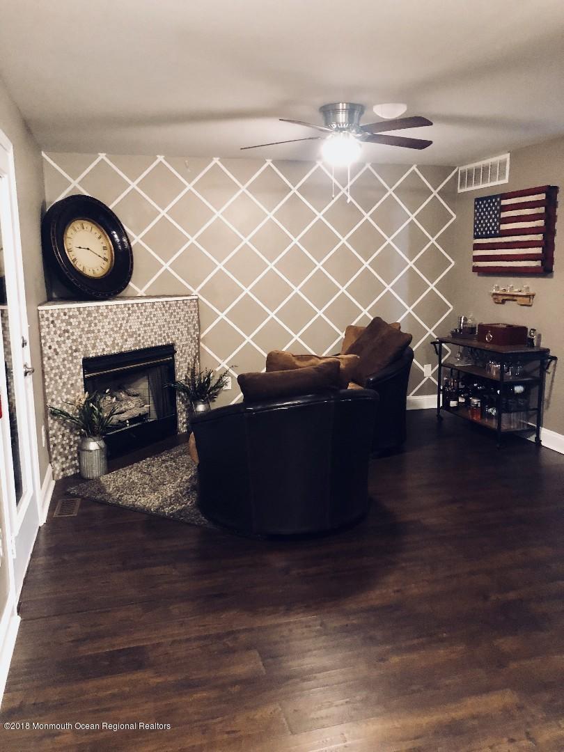 220 Schooner Road Manahawkin, NJ 08050 - Photo 18 of 25 a living room with a fireplace and a wooden floor