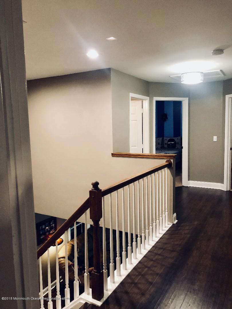 220 Schooner Road Manahawkin, NJ 08050 - Photo 3 of 25 a view of a hallway with wooden floor and windows