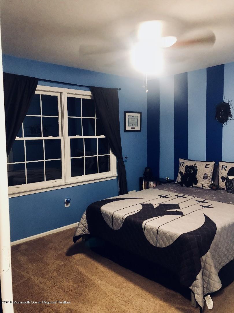 220 Schooner Road Manahawkin, NJ 08050 - Photo 5 of 25 a bed sitting in a bedroom next to a window