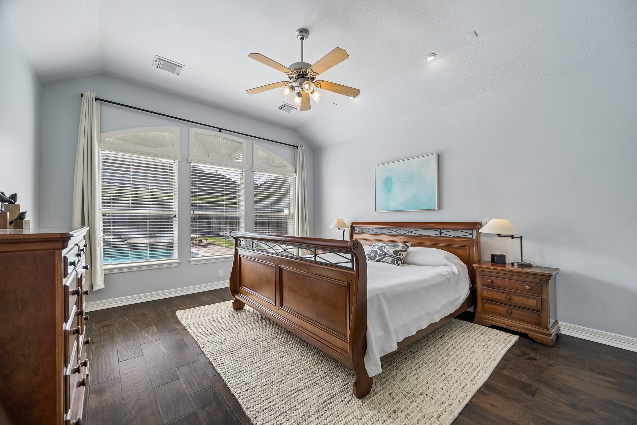 5718 Brennan Ridge Lane Katy, TX 77450 - Photo 15 of 42 A PRIVATE RETREAT TO START AND END YOUR DAY: Spacious and serene, the primary suite features rich hand-scraped wood floors and a wall of windows overlooking the sparkling pool and backyard beyond.