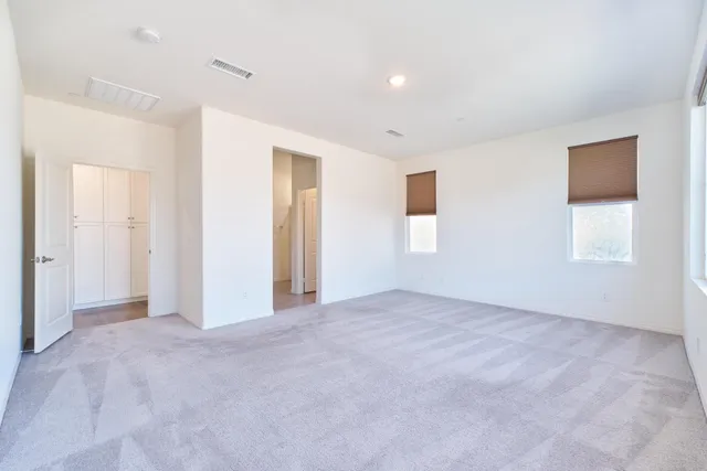 an empty room with windows and closet