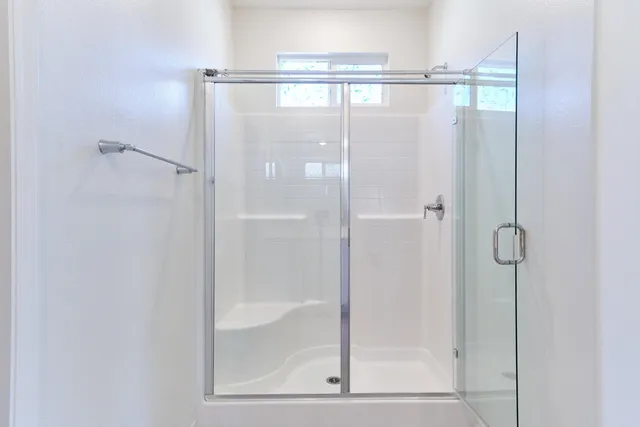 a bathroom with double sink large mirror and windows