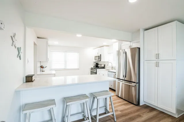 a kitchen with refrigerator a sink and white cabinets