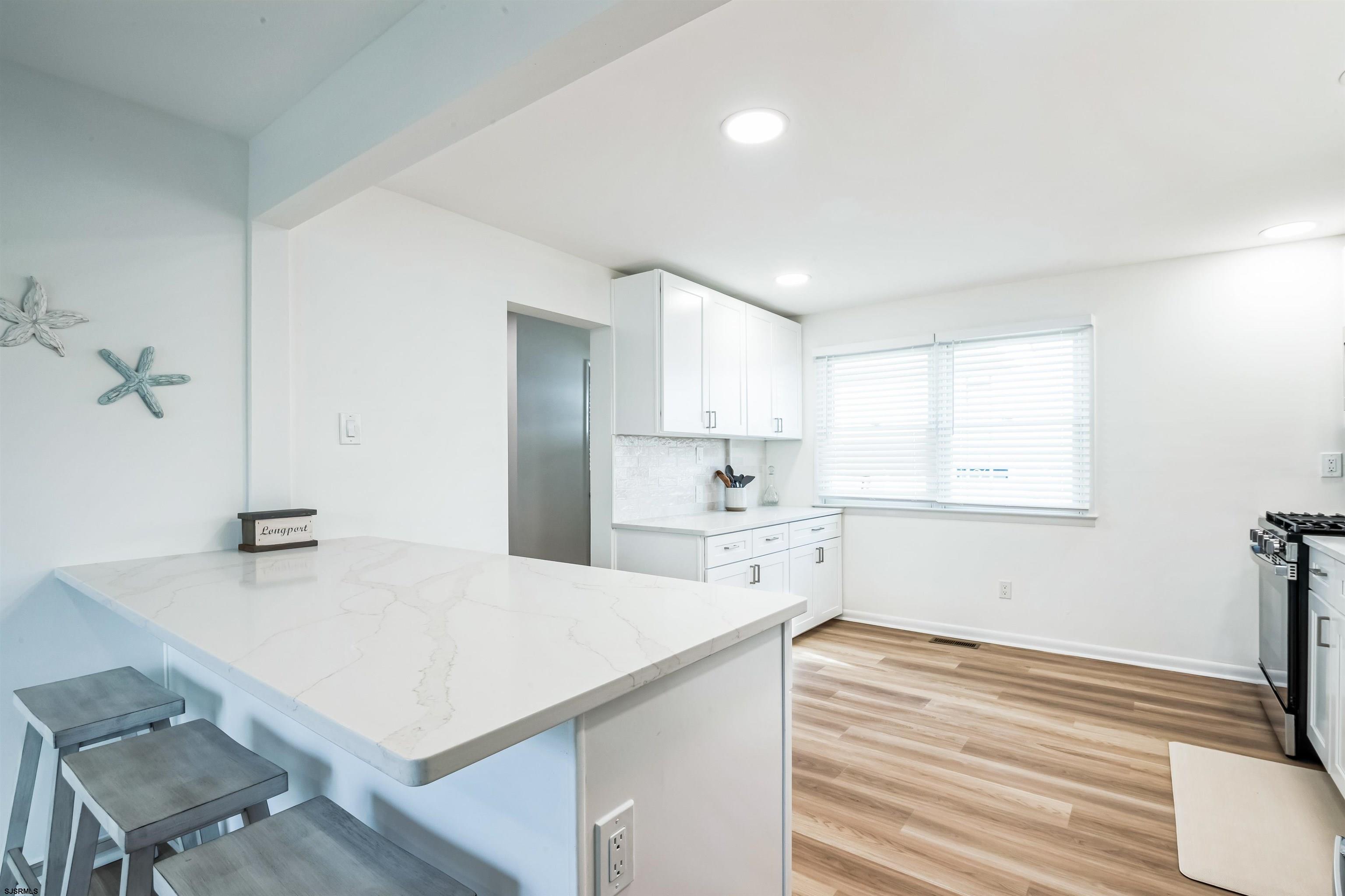 3304 Monmouth Avenue, Unit WINTER RENTAL Longport, NJ 08403 - Photo 13 of 29 a kitchen with a table chairs and a refrigerator