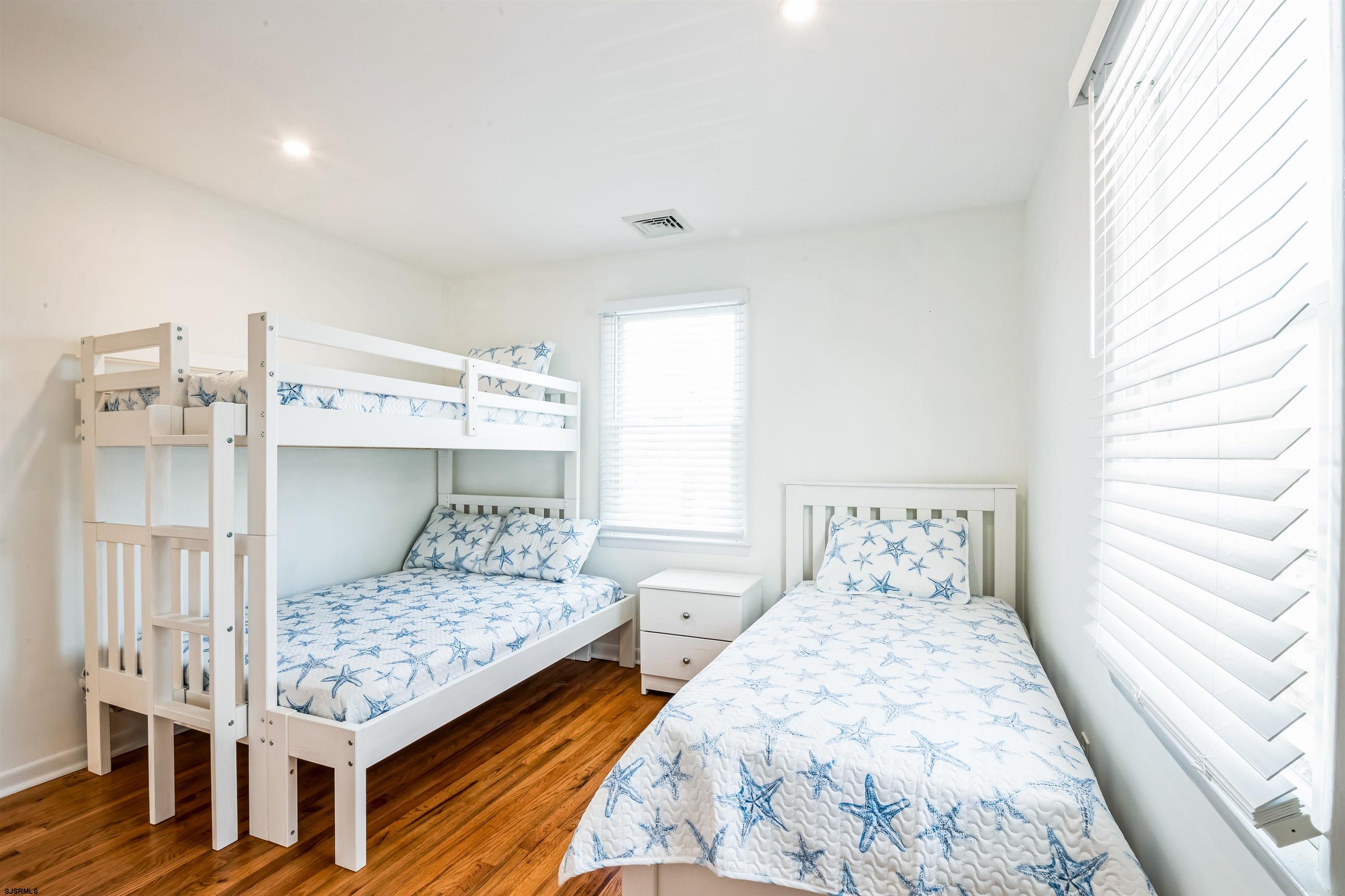 3304 Monmouth Avenue, Unit WINTER RENTAL Longport, NJ 08403 - Photo 20 of 29 a bedroom with a bed and wooden floor