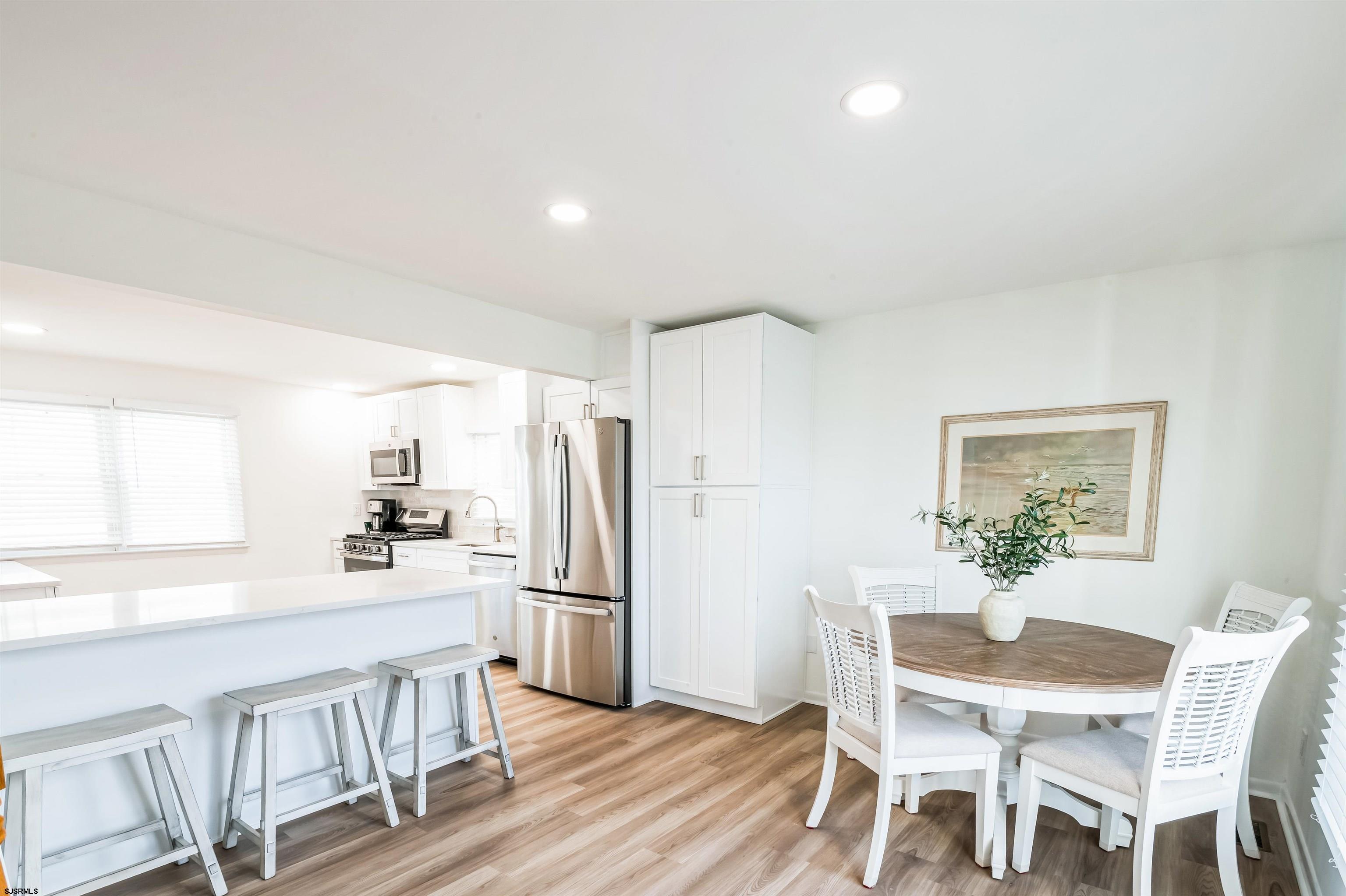 3304 Monmouth Avenue, Unit WINTER RENTAL Longport, NJ 08403 - Photo 9 of 29 a kitchen with white cabinets and wooden floor