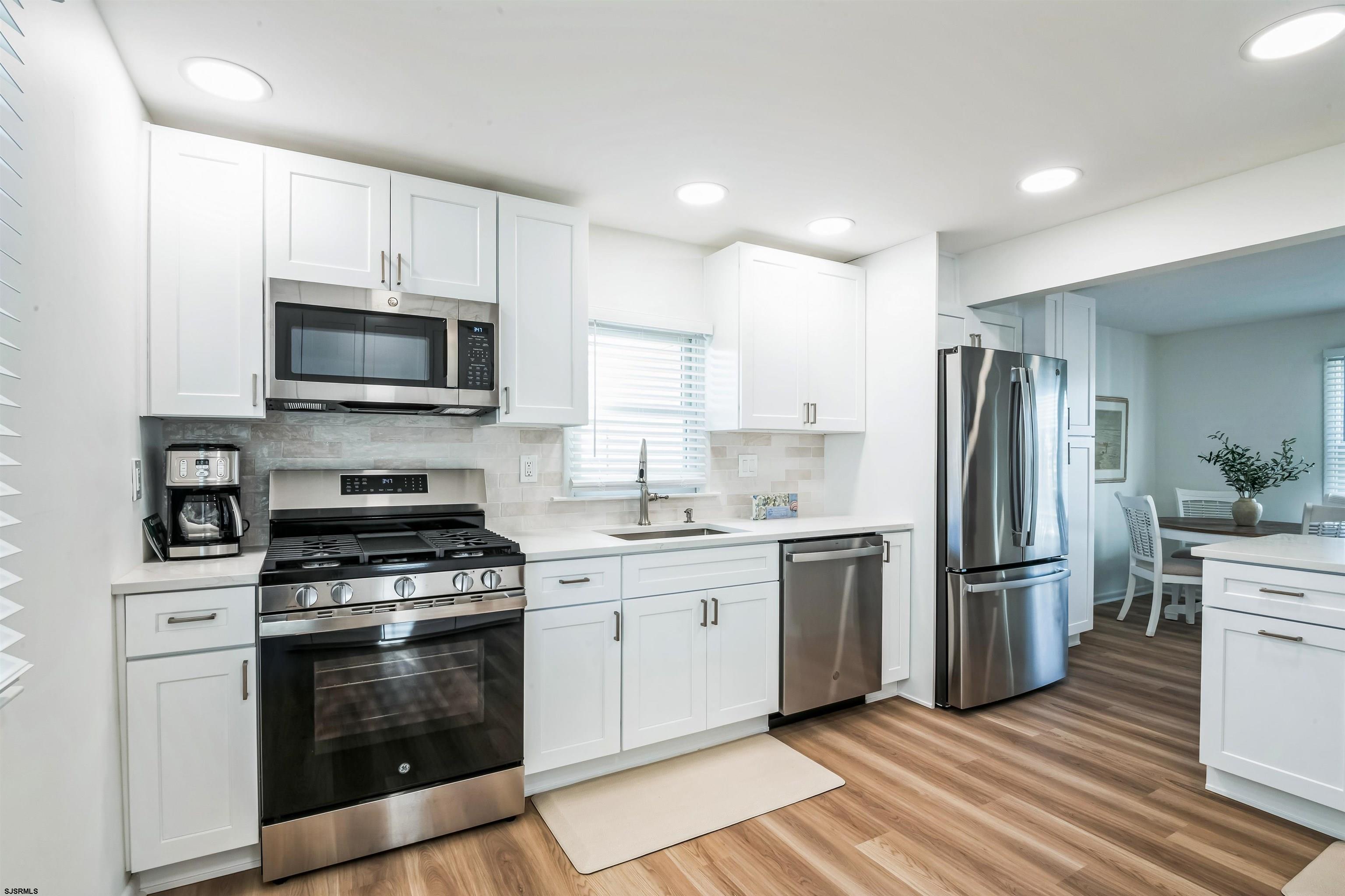 3304 Monmouth Avenue, Unit WINTER RENTAL Longport, NJ 08403 - Photo 10 of 29 a kitchen with stainless steel appliances a refrigerator a stove top oven a sink and cabinets