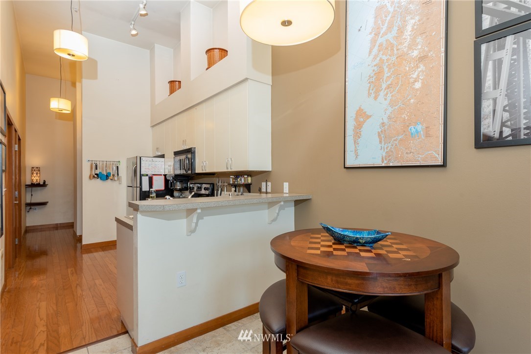 910 Gladstone Street, Unit 309 Bellingham, WA 98229 - Photo 7 of 25 a kitchen with stainless steel appliances kitchen island a table chairs and a refrigerator