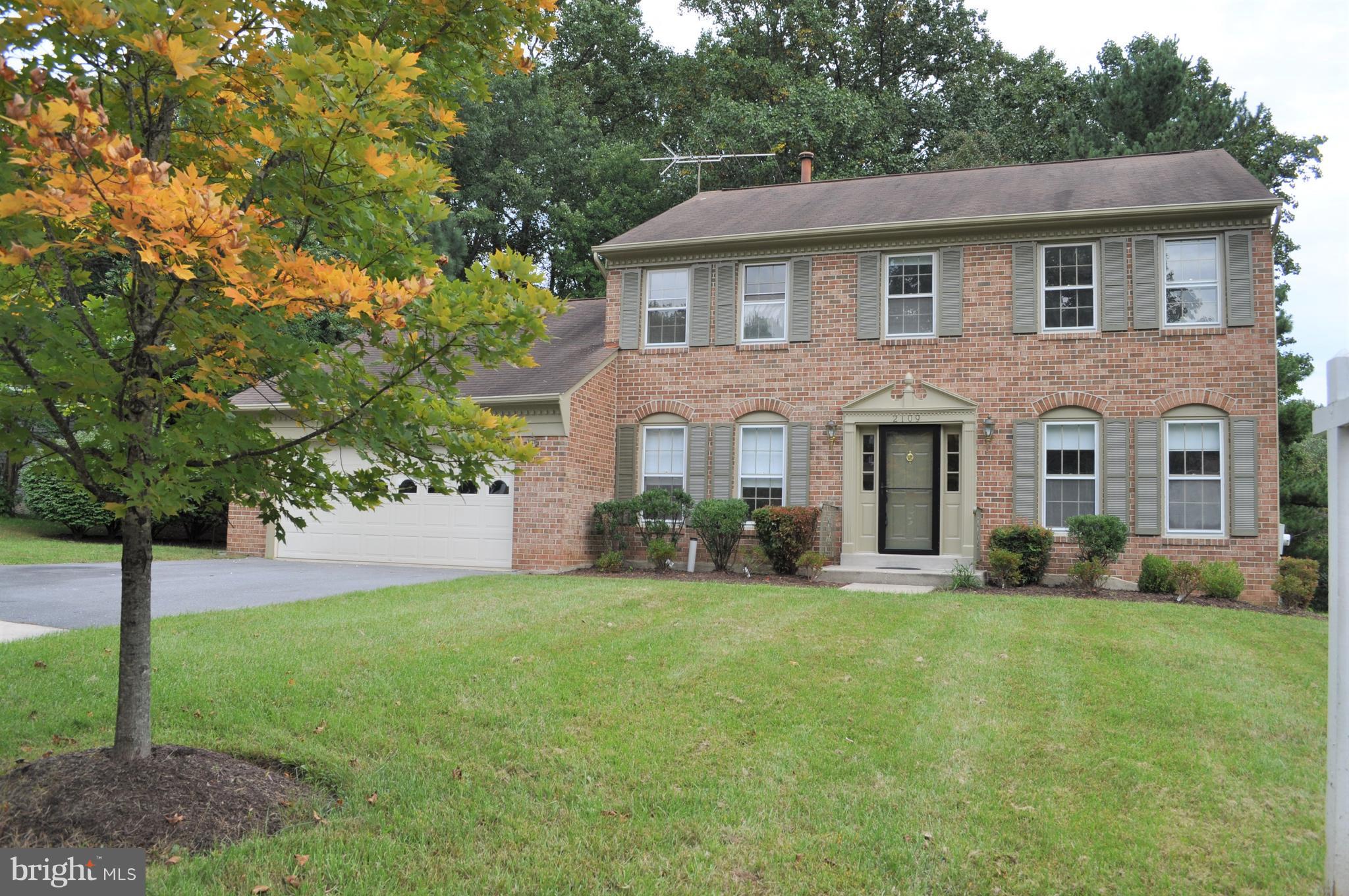 a front view of a house with a yard and trees