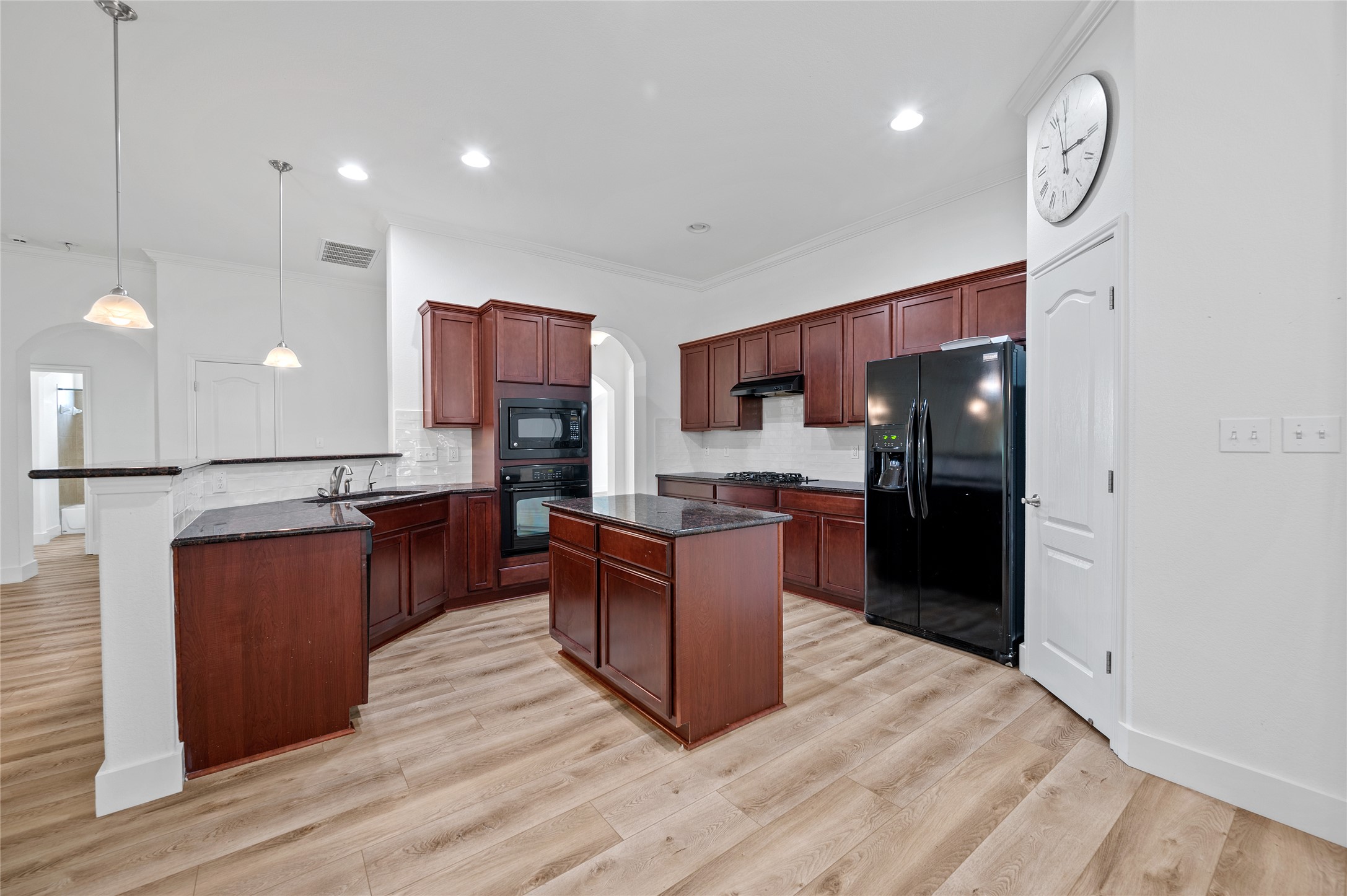 4512 Pyrenees Pass Bee Cave, TX 78738 - Photo 8 of 35 a large kitchen with stainless steel appliances kitchen island granite countertop a refrigerator stove a sink dishwasher and wooden cabinets with wooden floor