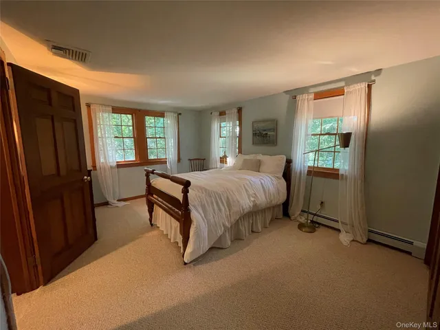 a bedroom with a bed dresser and a window