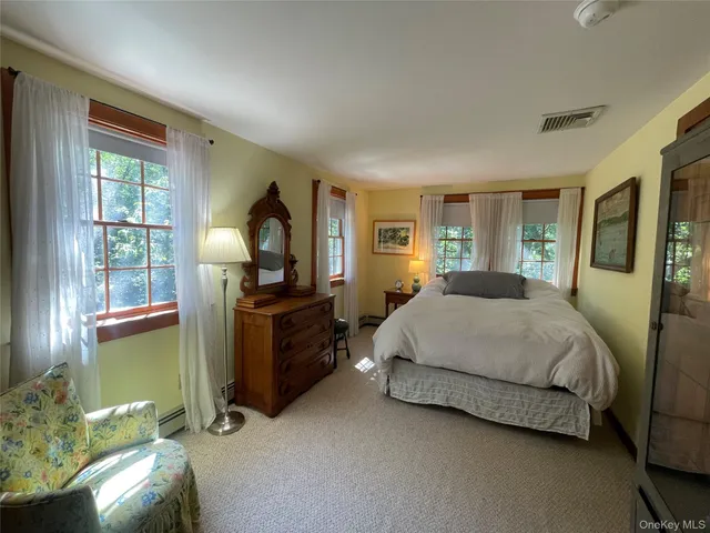 a bedroom with a bed dresser and a window