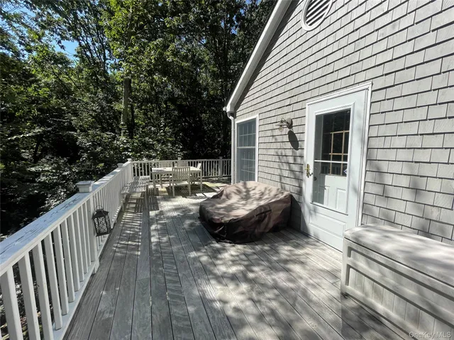 a view of a deck with table and chairs with wooden floor and fence