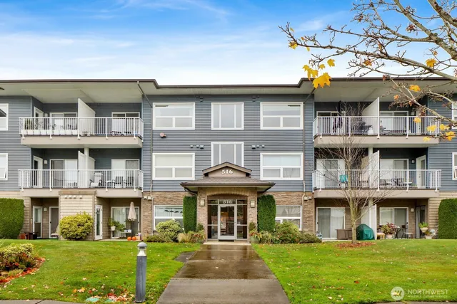 a front view of a residential apartment building with a yard