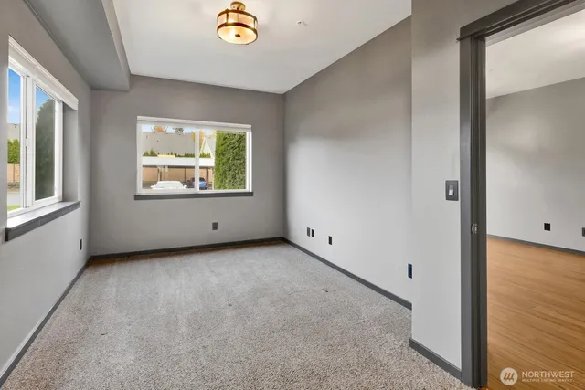 an empty room with windows and mirror