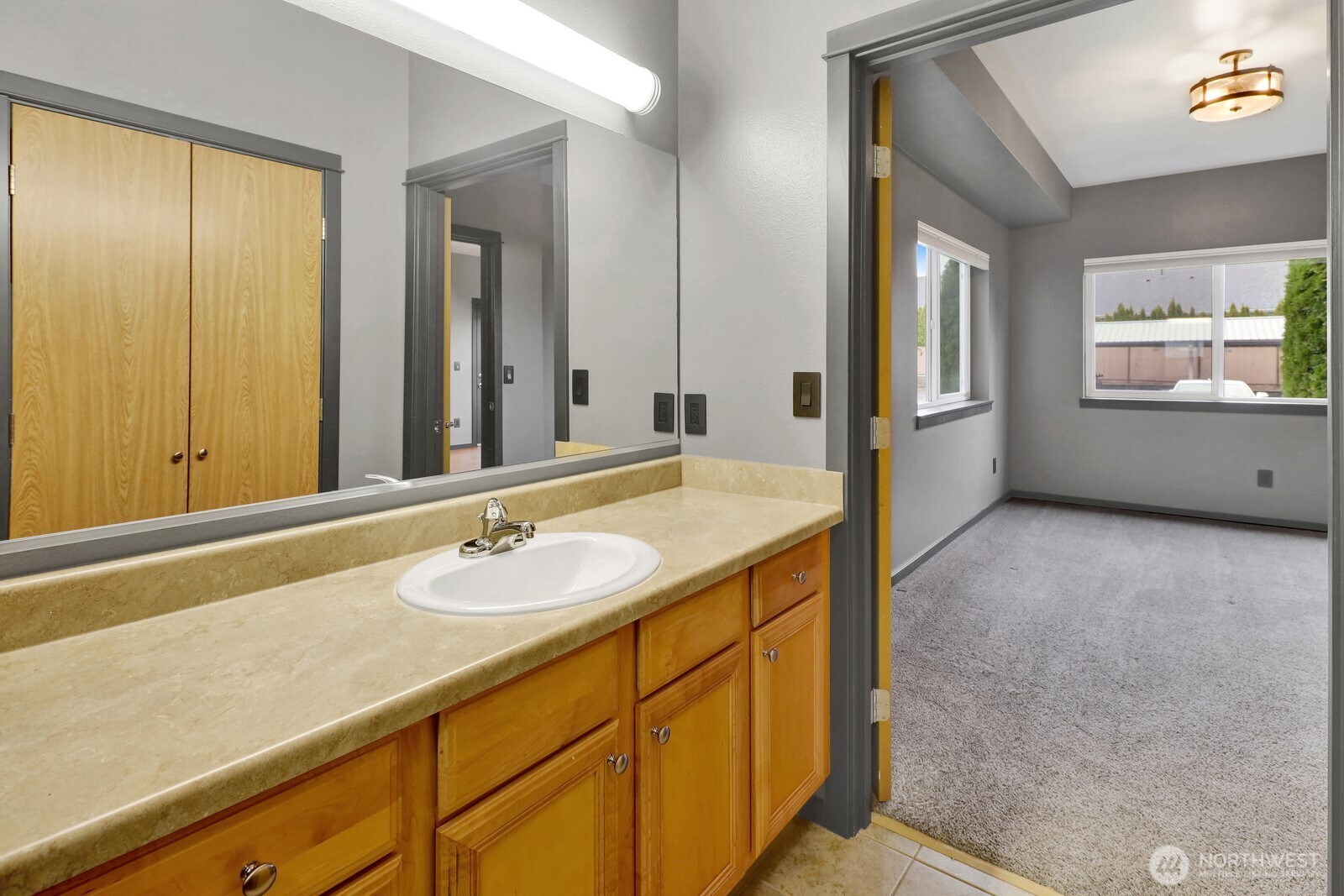 516 Darby Drive, Unit 104 Bellingham, WA 98226 - Photo 28 of 40 a bathroom with a granite countertop sink and a mirror