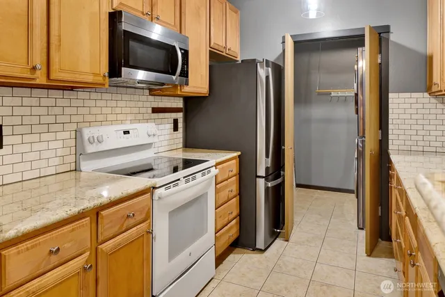 a kitchen with stainless steel appliances a refrigerator stove and microwave