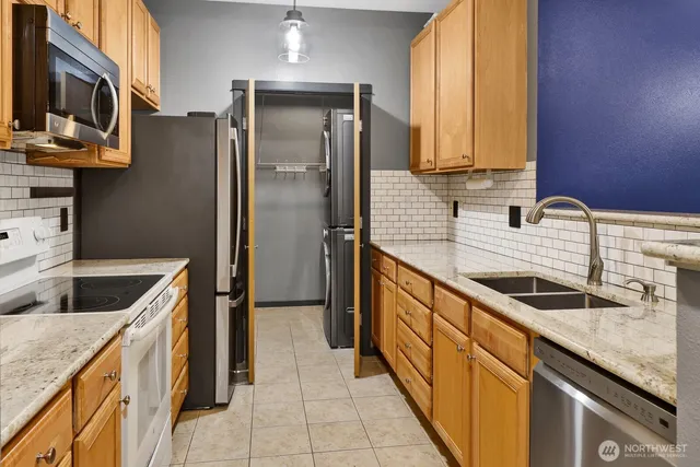 a kitchen with stainless steel appliances granite countertop a sink stove and refrigerator