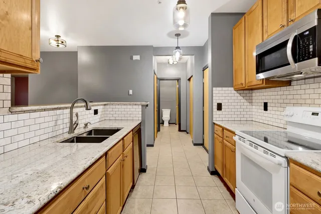 a kitchen with stainless steel appliances granite countertop a sink and a stove