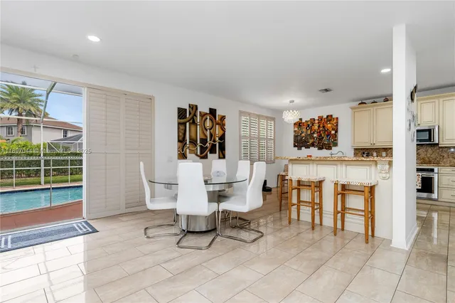 a dining room with furniture and large windows