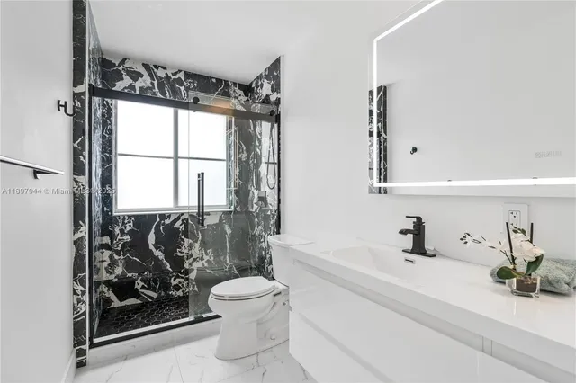 a bathroom with a bathtub sink vanity mirror and toilet