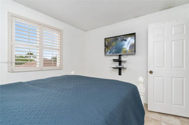 a view of a bedroom with a hardwood and a window
