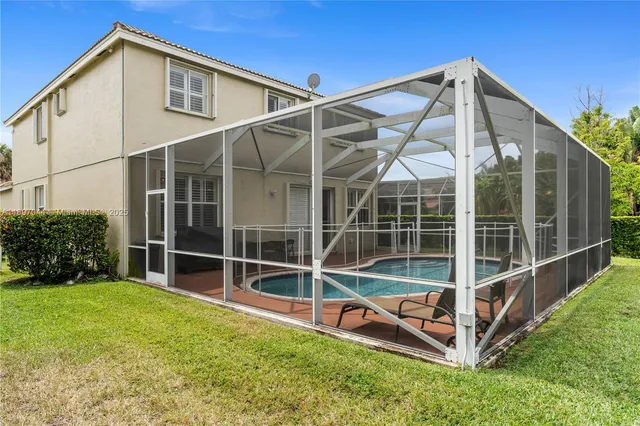 a view of a backyard with wooden fence and a small garden