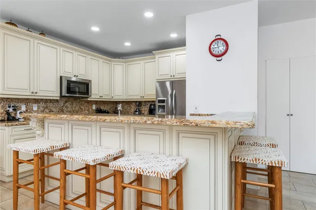 a kitchen with stainless steel appliances granite countertop a stove top oven a sink and white cabinets
