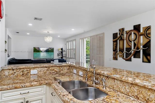 a kitchen with a sink and a large mirror