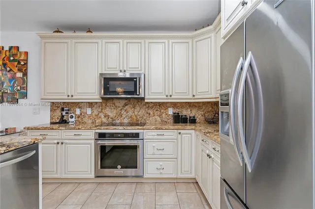 a kitchen with white cabinets and stainless steel appliances