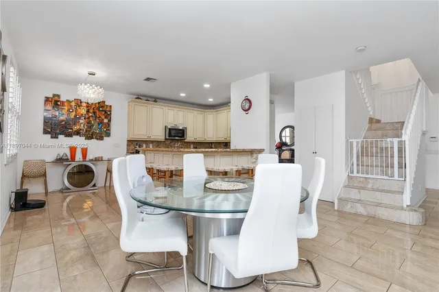 a kitchen with a dining table chairs and view of living room