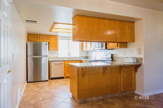 1116 Lee Avenue Ridgecrest, CA 93555 - Photo 10 of 32 a kitchen with stainless steel appliances granite countertop a refrigerator and a sink