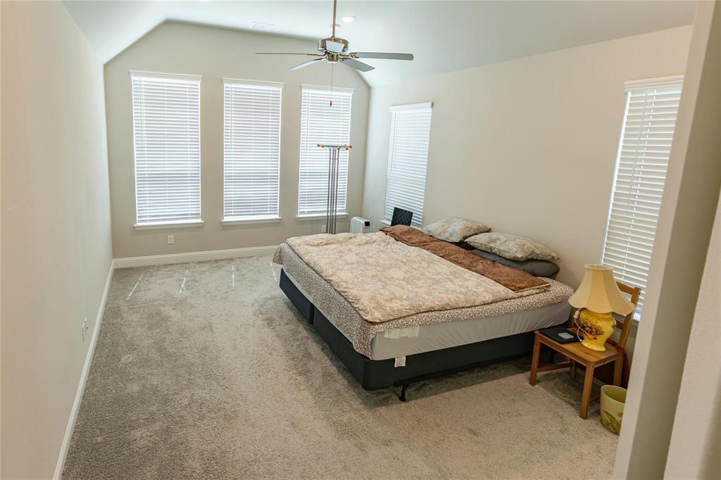 3920 Bentgrass Road Plano, TX 75023 - Photo 22 of 30 a bedroom with a bed and a chandelier