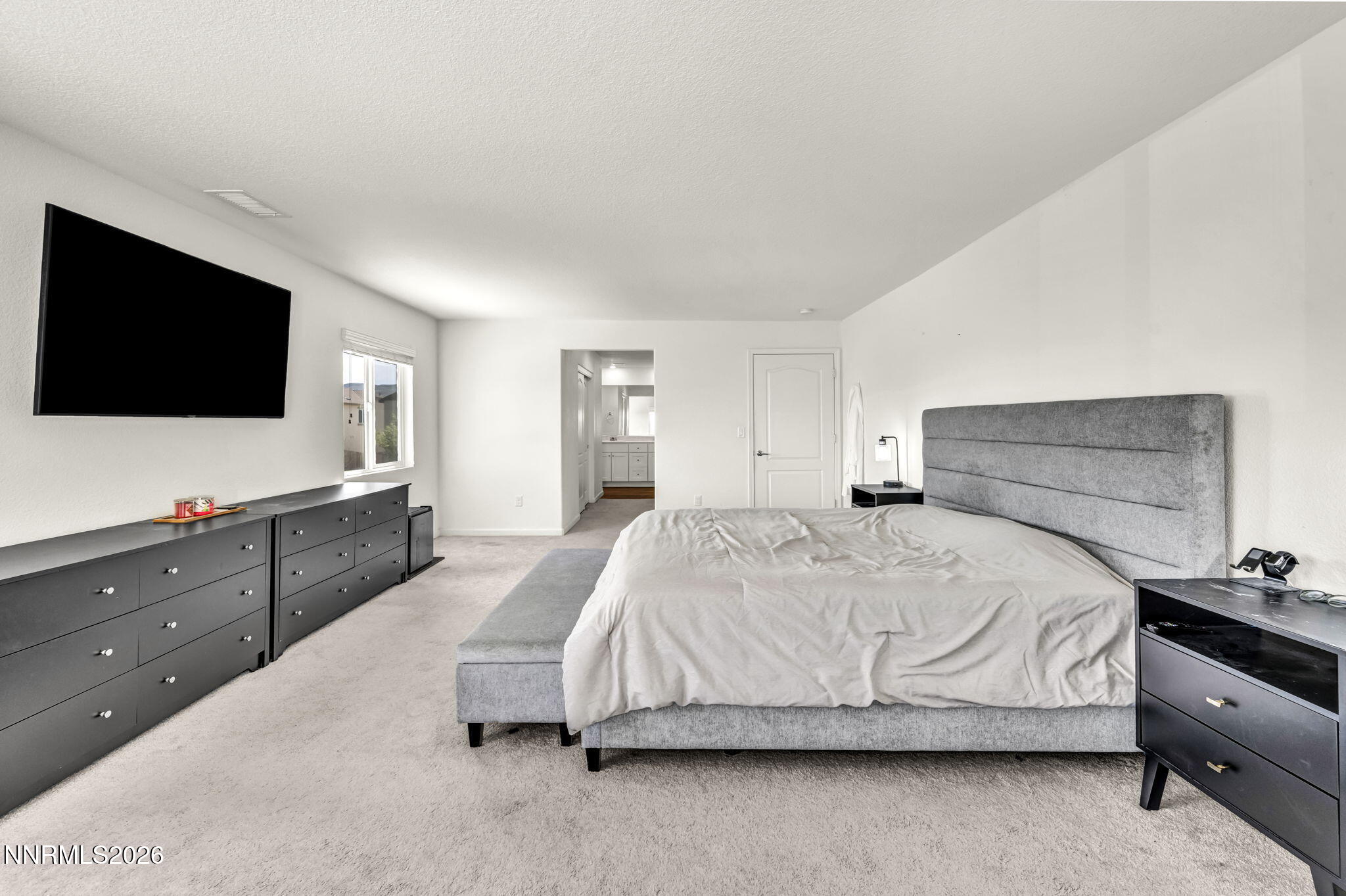 8982 Wolf River Drive Reno, NV 89506 - Photo 40 of 65 a spacious bedroom with a bed and a flat screen tv