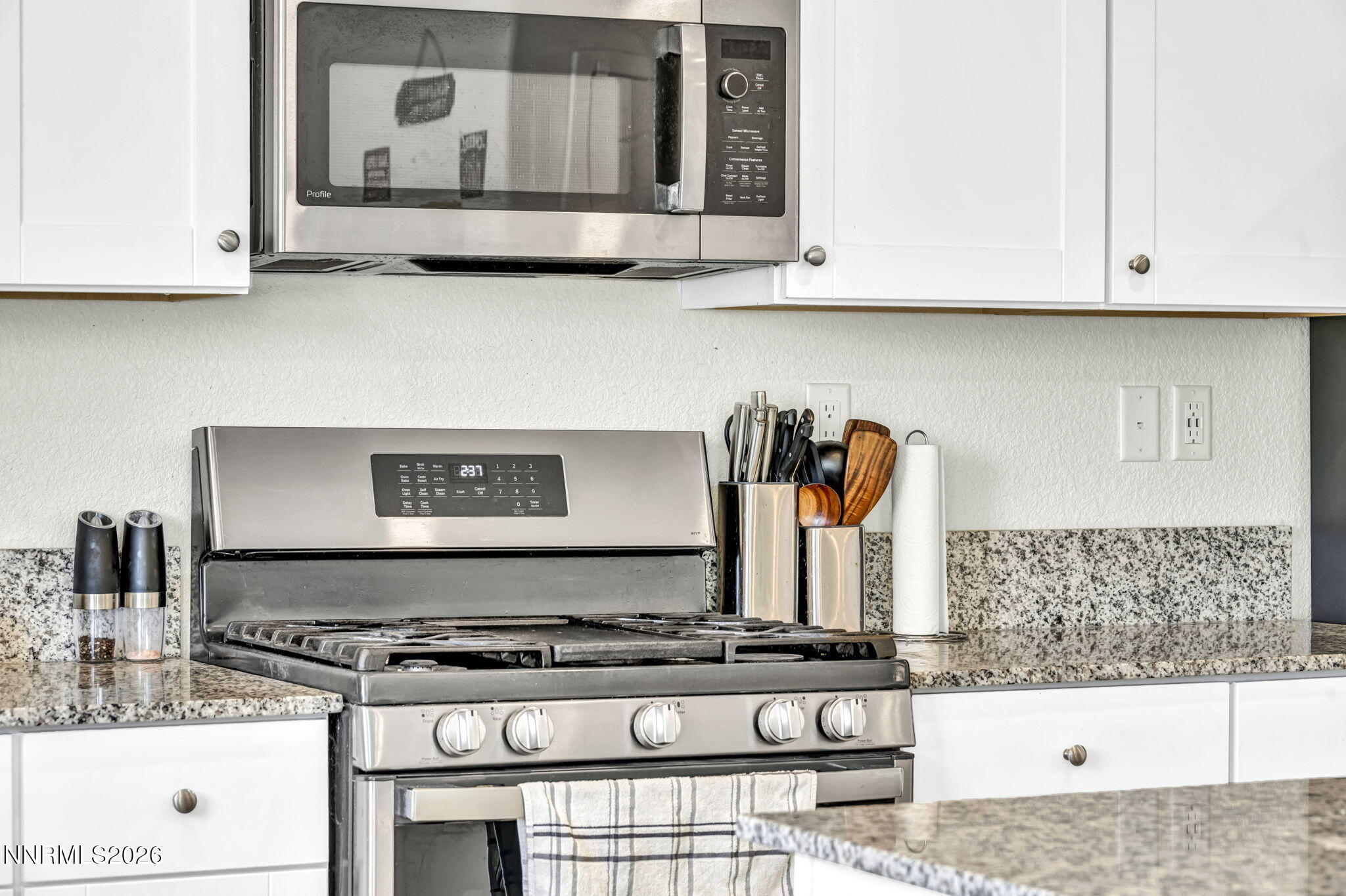 8982 Wolf River Drive Reno, NV 89506 - Photo 49 of 65 a kitchen with stainless steel appliances granite countertop a stove and a microwave