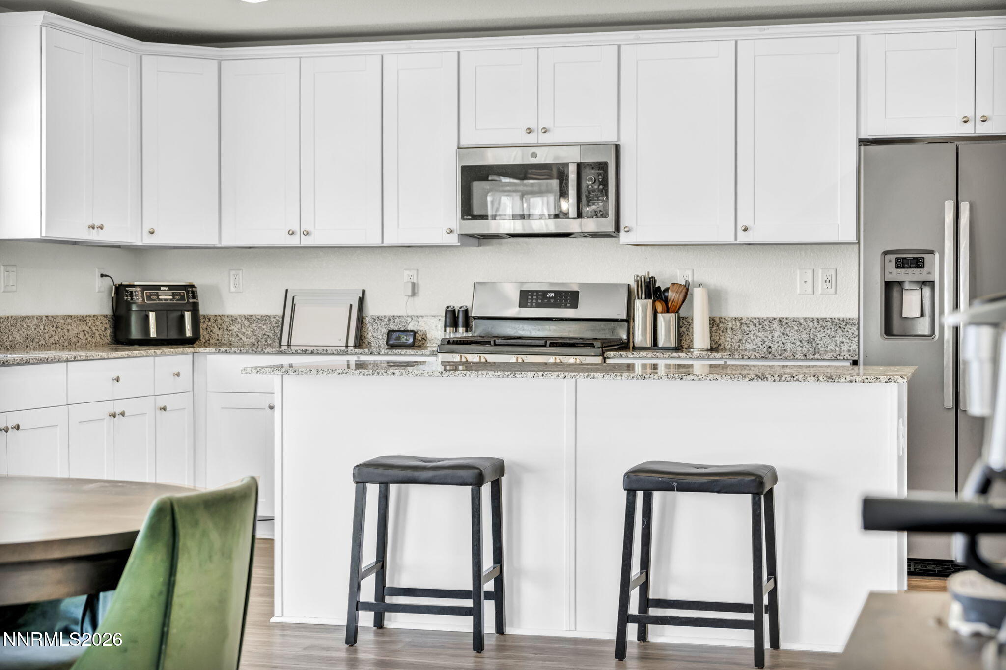 8982 Wolf River Drive Reno, NV 89506 - Photo 52 of 65 a kitchen with stainless steel appliances granite countertop a refrigerator a stove a sink and white cabinets with wooden floor