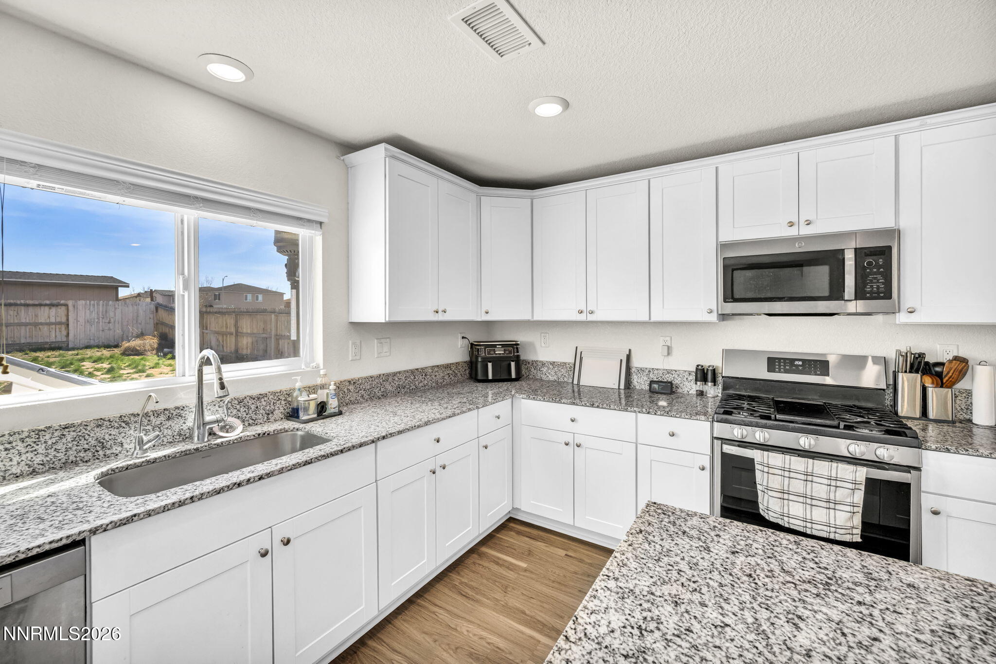 8982 Wolf River Drive Reno, NV 89506 - Photo 8 of 65 a kitchen with granite countertop a sink a counter top space appliances and cabinets