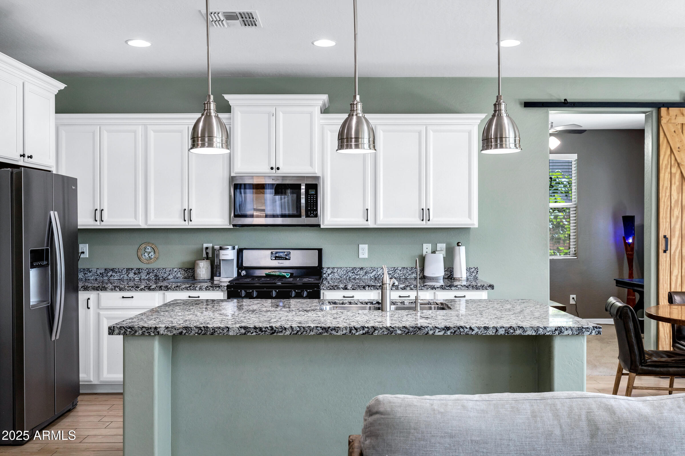 41311 West Elm Drive Maricopa, AZ 85138 - Photo 7 of 25 a kitchen with stainless steel appliances granite countertop a sink a stove a refrigerator a center island and cabinets