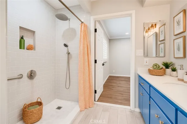 a bathroom with a granite countertop sink a mirror and shower