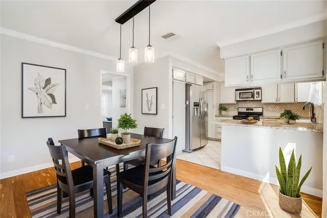 a dining room with stainless steel appliances kitchen island granite countertop furniture and a dining table
