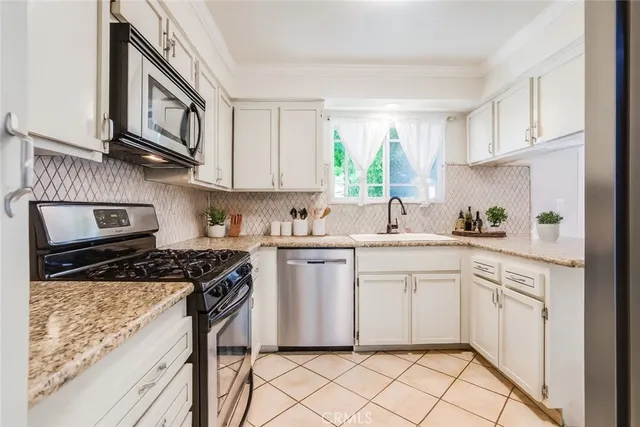 a kitchen with stainless steel appliances granite countertop a stove sink and cabinets