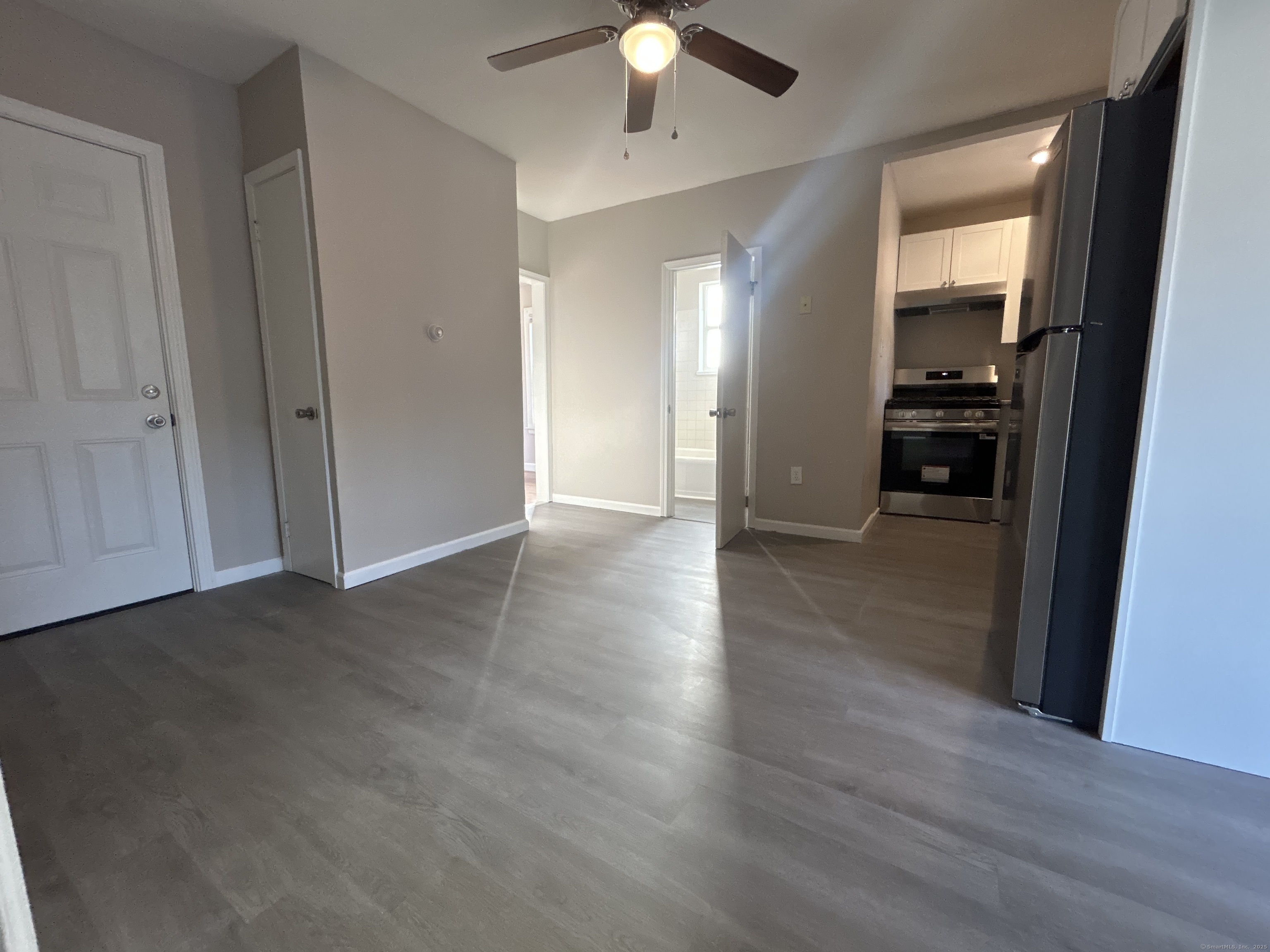 120 South End Road New Haven, CT 06512 - Photo 2 of 14 an empty room with wooden floor and way to kitchen
