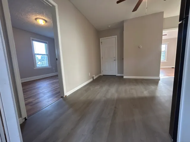 an empty room with wooden floor and windows